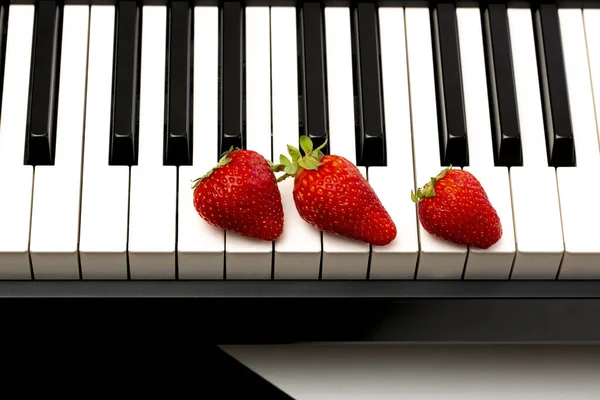 Три Спелых Клубники Клавишах Пианино — стоковое фото