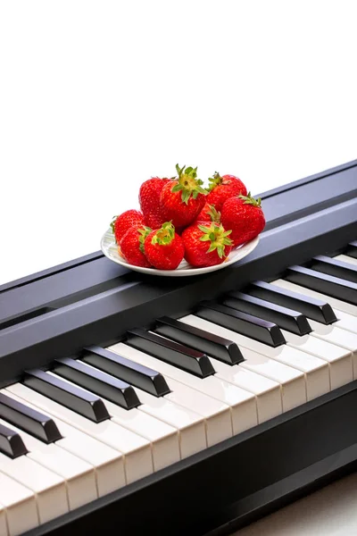 ピアノの鍵の上の3つの熟したイチゴ — ストック写真