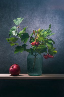 Elma ve bir dal kırmızı viburnum cam bir kavanozda suyla