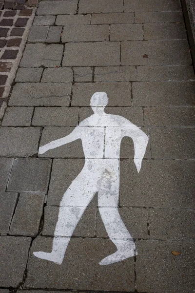 A drawing of a silhouette of a man on the road, marking a path for pedestrians