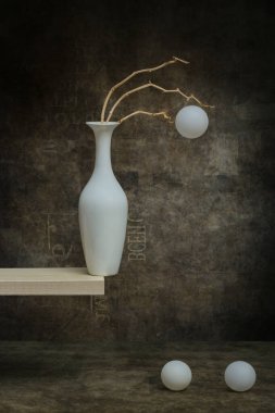 Durgun bir hayat beyaz bir vazoda beyaz toplarla