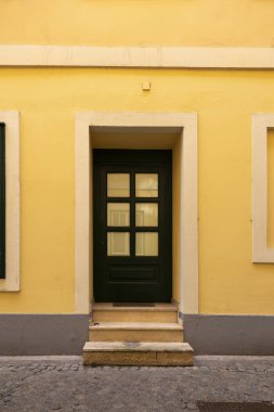 Bir apartmanın ön cephesinde basamakları olan bir kapı.
