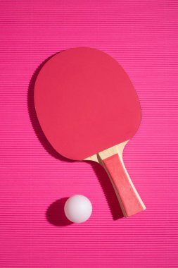 Pembe arka planda masa tenisi raketi