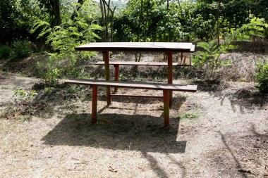 Bir kır evinin bahçesindeki banklı masa.