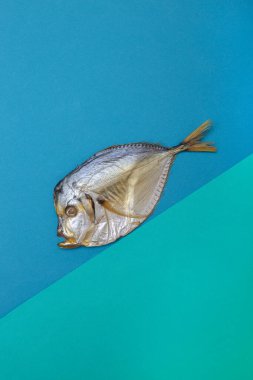 Renkli bir arkaplan üzerinde tütsülenmiş deniz balığı.