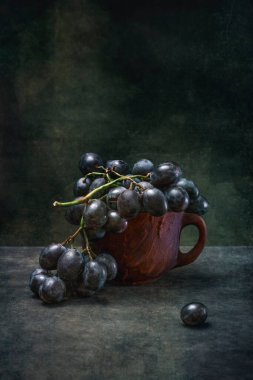 Kahverengi bir kupada olgun üzümlerle dolu bir hayat