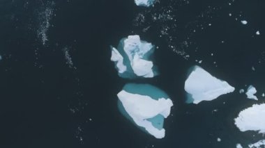 Beyaz ve mavi Iceberg yukarıdan aşağıya insansız hava aracı görüntüsü. Antarktika uçuşu. Kutup kışı okyanus suyunun ortasındaki kar beyazı buz dağına bakın. Dokunulmamış vahşi doğanın güzelliği. görüntüler.