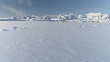 Antarktika 'daki sonsuz kutuplu karlı çöl. Güney Kutbu 'nun buz tabakası. Bilimsel taban. Kar ufukta dağları kapladı. Hava manzaralı uçuş. Buz Manzarası. Donmuş kış insansız hava aracı
