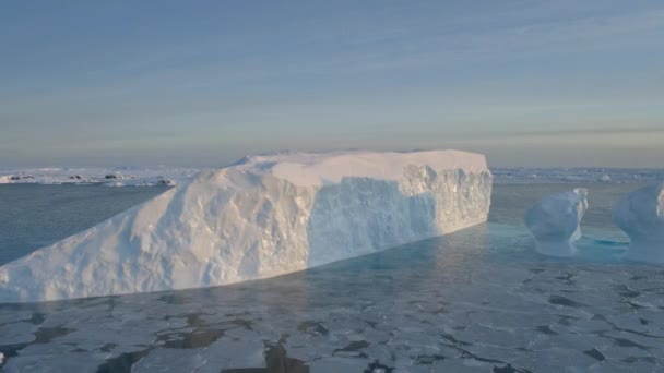 日落了蓝色的大冰山在空中近距离拍摄 白色的南极全景无人驾驶飞机飞行视图 极地海洋之间的冰 冰山在冰冷的水中漂浮 永冻土南极大陆 — 图库视频影像