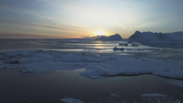 南極海岸で夜明け 極夜の夕日 海は氷を覆った 上空からの眺め 南極の雪山 スカイサンライズ 南極の冬 開いた水 美しい空の風景 トップ — ストック動画