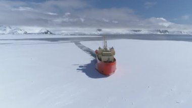 Antarktika sularında yol alan buz kırıcı gemi buzu kırarak geliyor. Hava görüntüsü. Kırmızı renkli Laurence M. Gould Araştırma Teknesi Güney Okyanusları 'nın buzlarını kesiyor.