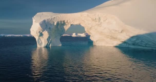 南極大陸の大きな氷河のアーチにドローン飛行 極性の自然環境を融解する巨大な穴 北極の冬の風景 地球温暖化問題 気候変動 晴れた冬の日 — ストック動画