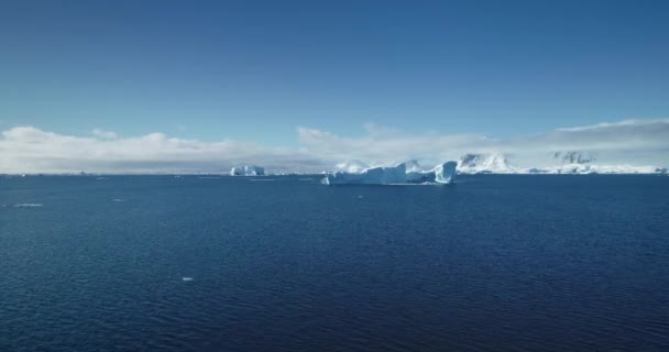寒冷的南极洲蓝水海洋无人驾驶飞机飞行 冰山来自融化的冰川 在阳光灿烂的日子里漂浮着 极地夏季场景 生态学 融化的冰 气候变化 全球变暖的概念 自然背景 — 图库视频影像