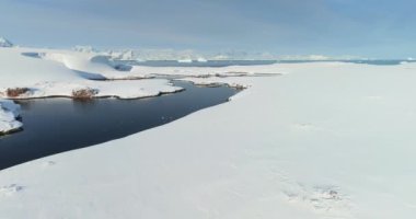 Antarktika 'nın el değmemiş vahşi doğası. Çöl beyazı karlar, soğuk okyanus nehri, arka planda dağlar. Seferler ve maceralar, Güney Kutbu 'na seyahat. Sinematik İHA görüntüleri