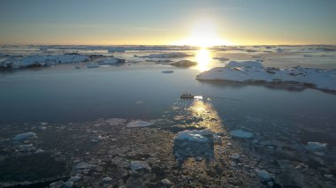 Antarktika okyanusta tekne. Havadan görünümü drone uçuş. Turistik zodyak lastik tekne Kutup okyanus su buzdağları arasında hareketli günbatımı sahne genel bakış. Antarktika Yarımadası. 4 k görüntüleri.
