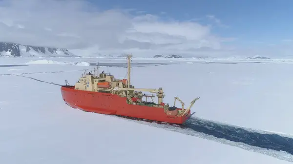 Batı ANTARCTICA - 23 Kasım 2017: Antarktika Buzkıran Gemisi Buz Uçurumu Atışı. Zaman ayarlı. Laurence M. Gould Araştırma Teknesi Güney Okyanusu 'nda yüzüyor. Donmuş Buzul Dağ Manzarası Tepesinde.