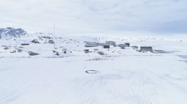 Antarktika penguenler koloni, Vernadsky istasyonu üzerinden hava Zoom uçuş. Kar yüzeyi, Güney Kutbu bağlar kaplı. Bir mekan Kışın kar manzara arasında. Drone Zoom Out genel bakış. 4k görüntüleri.