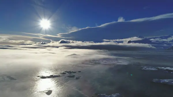 4 k Antarktika manzara. Havadan görünümü drone uçuş. Güneş tarafından hafif sis kaplı okyanus beyaz parlak kutup güneşi izlemek. Buz ve kar Antarktika kıtası yüzeyi kaplı. Panoramik genel bakış.