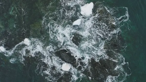 Okyanus dalgası kar Rock hava yukarıdan aşağıya görünümü. Su uçurum köpük içinde güzel sahil Cliff. Güç deniz Aqua Surf kış Antarktika deniz manzarası doğa Drone uçuş görüntüleri 4 k Uhd vurdu