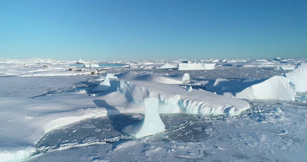 Polar Iceland winter landscape aerial panorama. Frozen ocean, glaciers, icebergs, blue sky in sunny day. Untouched wilderness of Antarctica, South Pole. Desert white land of snow and ice drone shot.