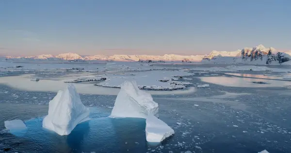 Melting glacier Antarctic winter landscape. Drone flight over Iceberg floating in frozen water. Environment ecological issue of global warming. Arctic winter landscape and climate change problem