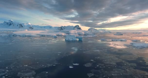 令人叹为观止的冬季北极空中日落景观 冰冻的美丽南极洲的自然 五彩斑斓的云彩映衬在极地冰冷的海水中 覆盖着高山 冰山的雪 — 图库视频影像