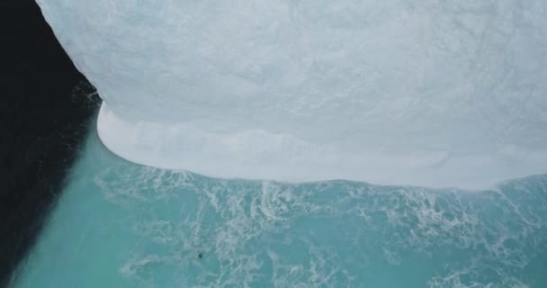 巨大的高耸冰墙冰川在南极洲 大雪覆盖着被寒流冲刷的冰山 漂流着极地的海洋 空中俯瞰无人驾驶飞机射击 探索南极野生动物 全球变暖 气候变化 — 图库视频影像