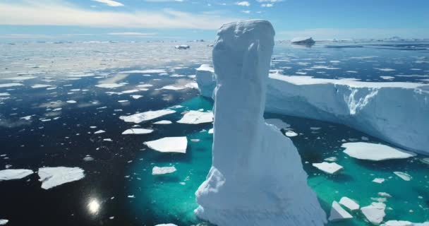 在北极冰冷的海洋中高耸融化的冰山 蓝天下白雪覆盖的冰川漂移 纯冰漂浮在碧绿的水中 生态学 融化的冰 气候变化 全球变暖 空中景观 — 图库视频影像