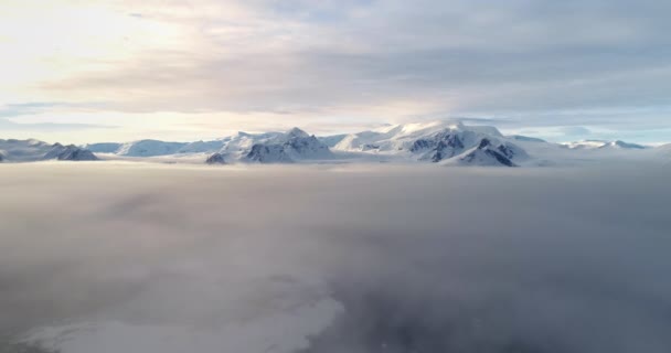 夕阳西下 威严的白雪覆盖的山顶 在南极洲 晨雾笼罩了整个天空 南极大陆的海洋航空观景面 野生大自然的背景无人机升空了 — 图库视频影像