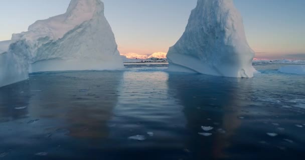 Grote Ijsbergen Drijven Oceaan Bij Zonsondergang Kleurrijke Lucht Reflecteren Koud — Stockvideo