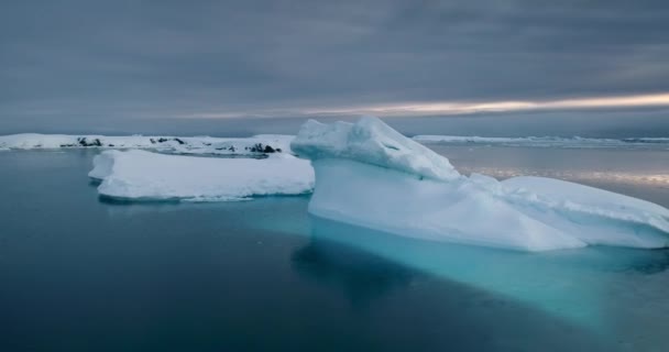 冰川融化在北极冰冷的泻湖中 白雪覆盖着多愁善感的天空 平静的水极冰封的冬季风景 自然的寒冷美丽的环境 南极野生动物全景射击 — 图库视频影像