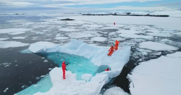 在南极洲 人们站在漂浮的冰山上 极地考察队的科学家们放松 在户外玩得很开心 冰天雪地 冰川融化 南极的野生生物 空中射击 — 图库视频影像