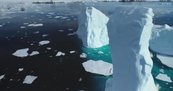 融化的冰山高耸在极地冰海之上 南极洲冰川融化在绿松石水中 北极冬季景观面临全球暖化问题 气候变化发生在阳光明媚的冬日 无人驾驶飞机射击 — 图库视频影像