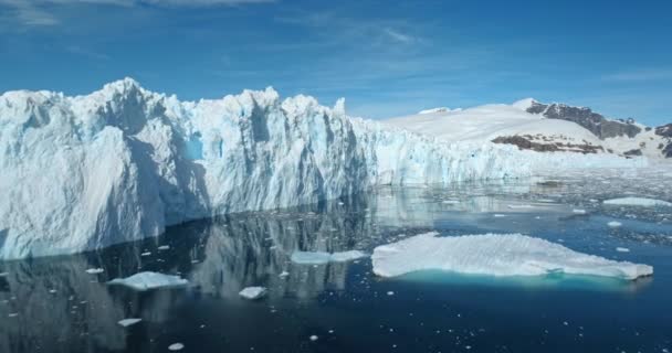南极洲阳光灿烂的日子里 冰川正在大规模融化 冰墙的形成和蓝天在平静的海水中反射 生态学 融化的冰 气候变化和全球变暖的概念 空中无人驾驶飞机镜头 — 图库视频影像