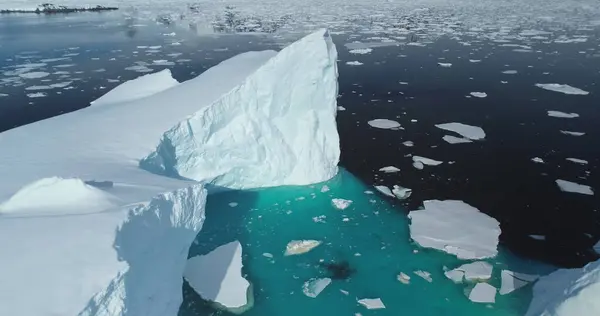Huge snow glacier melting in South Pole ocean. Crashed ice floating blue water. High icebergs in Antarctica. Environment ecological issue of global warming and climate change. Aerial drone panorama