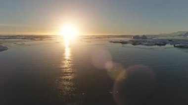 Antarktika Timelapse gün batımı. Hava gözlem insansız hava aracı hiperhıza geçti. Hızla okyanus suyu ve buzdağının üzerinden geçti. Parlak ışınlar verilmiş turuncu güneş ışığı. 4k görüntü.