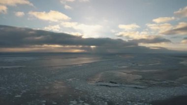 Antarktika sahilinde kutup gündoğumu. Okyanus buzla kaplı. Havadan bakıldığında üstte. Antarktika kar dağı. Gökyüzü gündoğumu Antarktika kışı. Açık deniz. Güzel gökyüzü manzarası. Üst İHA Uçuşu