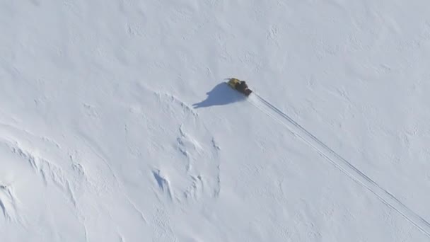 ヴィンテージスノーモービルライドスノーサーフェス 空中追跡ショット 南極の氷の覆われた土地へのスキードゥー旅行の遠征 Uhdでの極端なアクティビティトップドローンビューフッテージショット — ストック動画