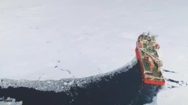 Kırmızı buzkıran gemisi Antarktika Buzu 'nu delip geçti. Antarktika hava görüntüsü. Laurence M. Gould Araştırma Gemisi Seyahati Kıta Kıyısı 'ndaki Donmuş Güney Okyanusu Buzul Sahası.