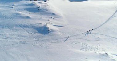 Kar Tepesi 'nde koşan sporcu grupları. Antarktika 'da karla kaplı yamaç, el değmemiş doğa. Soğuk güneşli bir günde kışlık kıyafet giyen adamlar. Aktif spor, turizm, eğlence. Havadan üst çekim