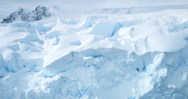 南极洲巨大的蓝色冰墙冰川 空中近距离飞越雪地覆盖着巨大的冰山表面 阳光灿烂 北极结冰的大自然之美 冬天的背景发现南极 — 图库视频影像