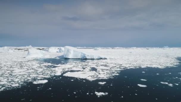 空中飞越南极海融化的冰和冰山 快速移动 天空中的云彩 冰片在阳光照耀的海洋中飘扬的无人机概览 白雪覆盖的高山背景 — 图库视频影像