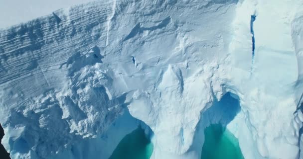 巨大的冰墙融化在北极水域的空中拍摄 南极洲的冰山漂浮绿松石水面向下俯瞰 巨大的冰川冰洞融化在海洋附近 全球变暖和气候变化 — 图库视频影像
