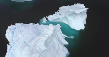 Eriyen buzdağları Arktik Okyanus 'ta sürüklenen hava manzarası insansız hava aracı panoramasını kapatır. Küresel ısınmanın çevresel ekolojik sorunu. Kutup buzullarının manzarasında iklim değişikliği. Antarktika vahşi doğa manzarası