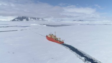 Antarctica Icebreaker Boat Break Ice Aerial Zoom in View. Laurence M. Gould Research Boat Float Through Thin Southern Ocean Frozen Surface at Packice Top Flight Drone clipart
