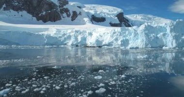 Antarktika 'da buzlu göldeki yüksek buzullar. Güneşli bir günde mavi gökyüzü. Doğa kış manzarası. Buzdağı arka planı eriyor. Ekoloji, eriyen buz, iklim değişikliği, küresel ısınma. Hava aracı görüntüsü