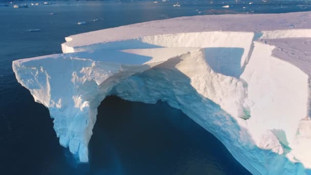 巨大的冰山漂移落日的极地海洋 南极洲巨大的冰川拱形山洞被撞毁了 巨大的冰墙在粉色的夜光中 北极冰冻的海洋景观 空中俯瞰无人机飞行变焦 — 图库视频影像