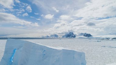 Antarktika Buzdağı üzerinde Uçuşlar, Okyanus. Beyaz Peyzaj. Buz Donmuş Okyanusun Hayret Verici Dronu. Bulutlu Gök ve Güneşli Karlı Dağlar Arkaplanı. Kış Güney Kutbu Sahnesi.