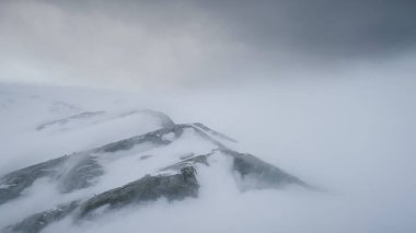 Antarktika Dağlarının Üzerinde Kar Fırtınası. Güney Kutbu üzerinde hava aracı. Sert Vahşi Çevre. Antarktika 'da Doğal Kutup Fenomeni yaz ortası. Gri Beyaz Çizgili Kış Manzarası.