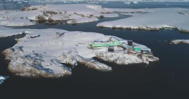 South Pole science polar station in Antarctica. Research Vernadsky base buildings on ocean coastline aerial drone view. Global warming, climate change, wild nature exploration. Antarctic expedition